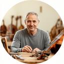 Maestro luthier frente al banco de trabajo con pinzas, madera y planos de instrumentos